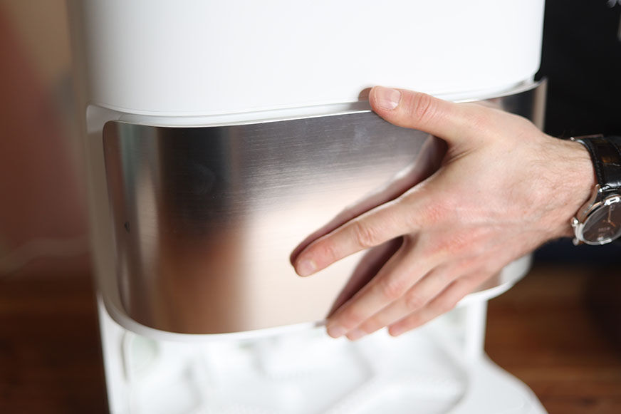 Die silberne, magnetische Klappe der Dreame L10s Ultra Basisstation wird abgenommen.